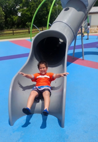 child playing on slide outside 2 at cadence academy wylie texas