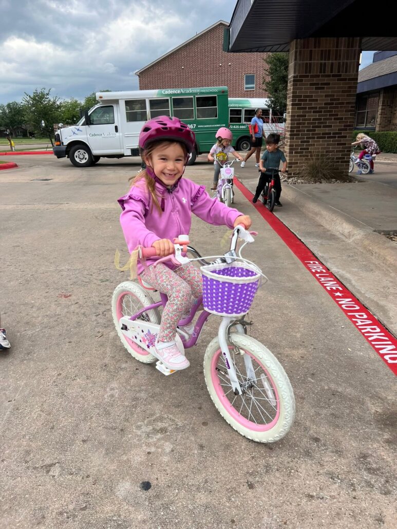 Child riding a bike at preschool and daycare at cadence academy preschool in the colony texas