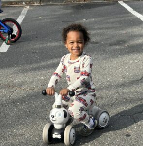 Child smiling and riding bike at cadence academy preschool and daycare raintree in charlotte, north carolina