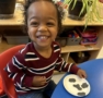 child smiling next to arts and crafts at cadence academy preschool and daycare raintree in charlotte, north carolina