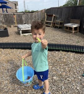 child smiling outside showing toy at preschool and daycare at cadence academy preschool in the colony texas
