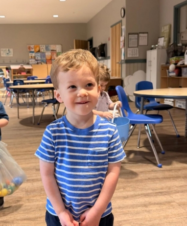 child smiling with easter eggs at preschool and daycare in grapevine texas