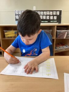 child writing at preschool and daycare at 365 cypress