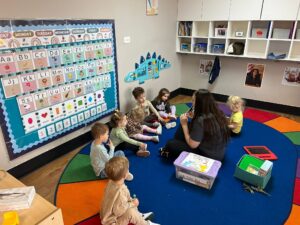 children listening to teacher read at preschool and daycare at cadence academy preschool in the colony texas
