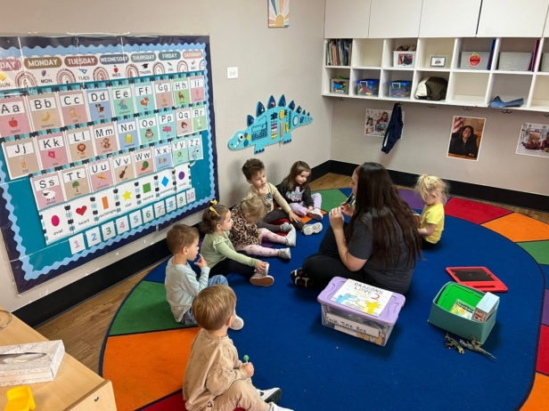 children listening to teacher read at preschool and daycare at cadence academy preschool in the colony texas