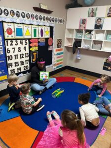 children listening to teacher read book at preschool and daycare at cadence academy preschool in the colony texas