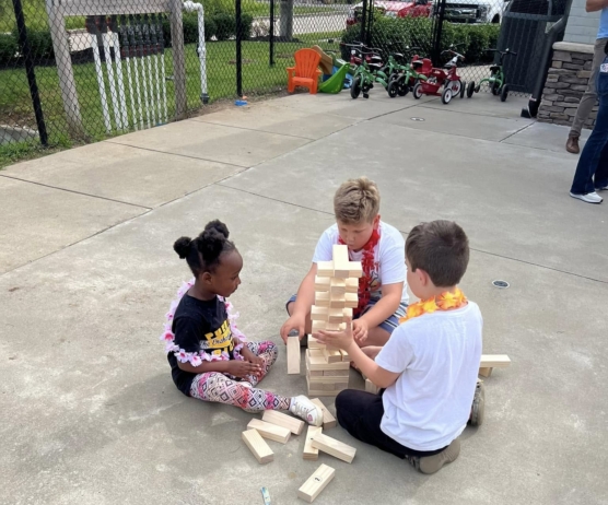 Children playing jenga together outside on the floor at Cadence academy preschool and daycare 505 murfreesboro
