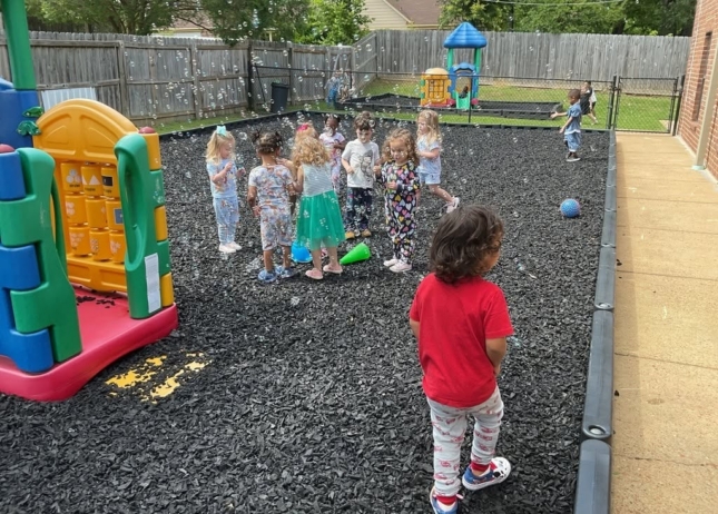 Children playing outside with bubbles at preschool and daycare at Cadence Academy Preschool Olive Branch, Mississippi
