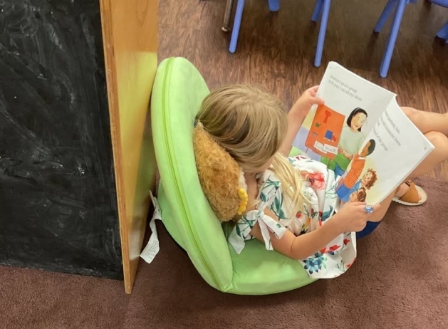 Child reading on floor at preschool and daycare at Cadence Academy Preschool Olive Branch, Mississippi