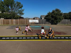 children riding tricycle at preschool and daycare at cadence academy preschool forney, texas