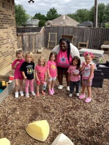 children smiling outside with teacher at preschool and daycare at cadence academy preschool in the colony texas