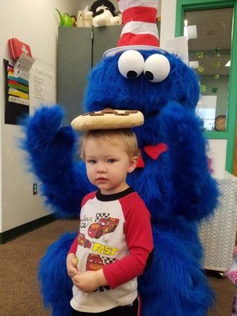 cookie_monster_putting_cookie_on_preschoolers_head_canterbury_preparatory_school_overland_park_ks-338x450