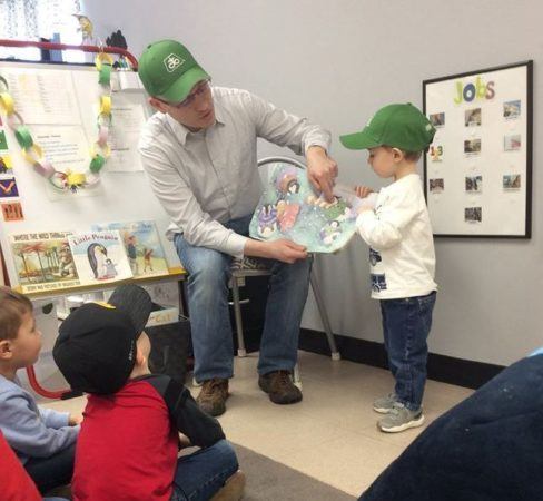 dad_reading_book_to_preschoolers_cadence_academy_preschool_clive_ia-488x450