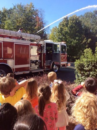 fire_man_demonstrating_hose_at_gateway_academy_mckee_charlotte_nc-336x450