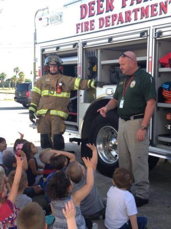 fireman_answering_questions_about_fire_truck_at_the_peanut_gallery_la_porte_tx-336x450