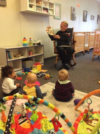 grandfather_reading_book_to_toddlers_cadence_academy_preschool_main_street_normal_il-336x450