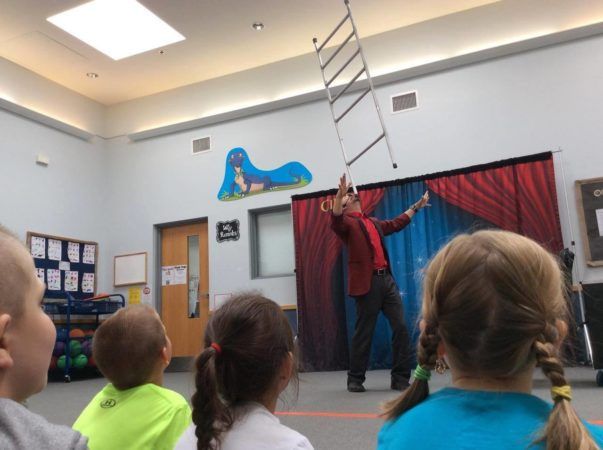 guest_performer_balancing_chair_on_chin_adventures_in_learning_oswego_il-603x450
