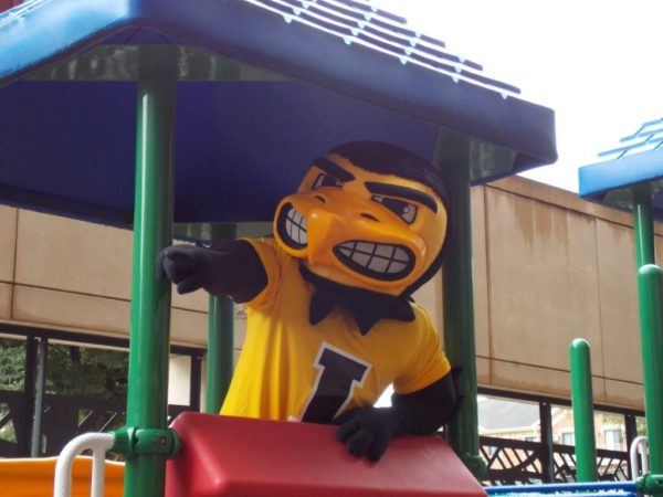 herky_the_hawk_on_playground_cadence_academy_preschool_iowa_city_ia-600x450