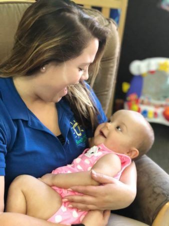 infant_and_teacher_enjoying_the_rocking_chair_sunbrook_academy_at_stilesboro_kennesaw_ga-338x450