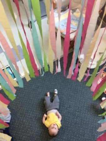 infant_under_streamers_at_next_generation_childrens_centers_andover_ma-338x450