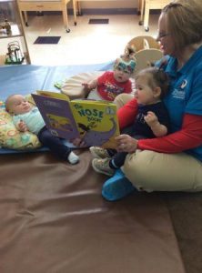 infants_reading_book_with_day_care_provider_at_phoenix_childrens_academy_private_preschool_thunderbird-333x450