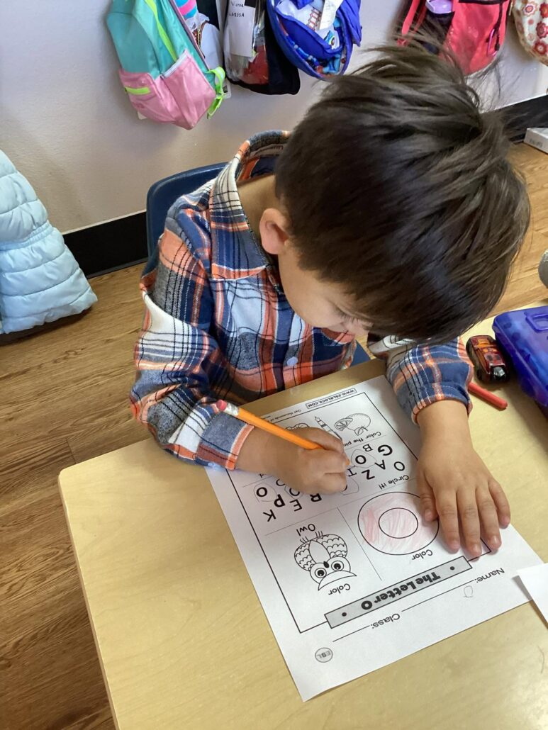 child completing worksheet to learn at preschool and daycare at cadence academy preschool in the colony texas