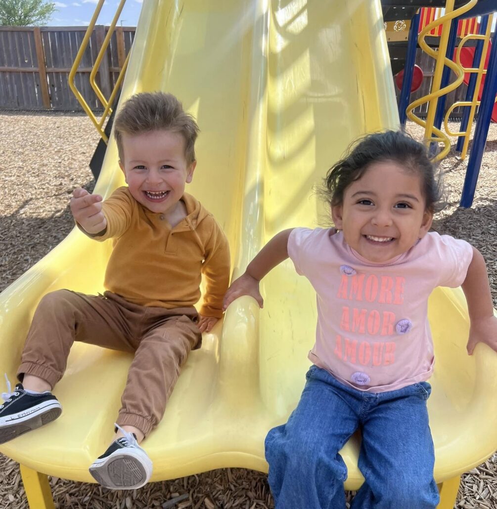 kids sliding down slide in playground at preschool and daycare at cadence academy preschool in the colony texas