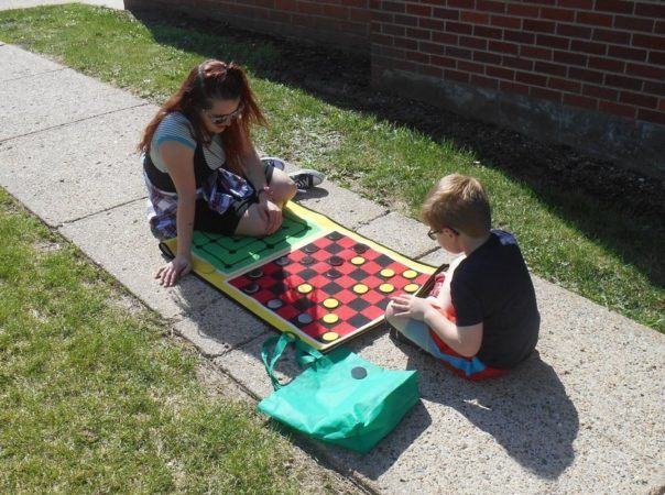 playing_checkers_with_teacher_cadence_academy_before_and_after_school_norwalk_ia-604x450