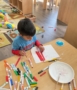 Child painting popsicle sticks with red paint at cadence academy preschool and daycare in dupont washington