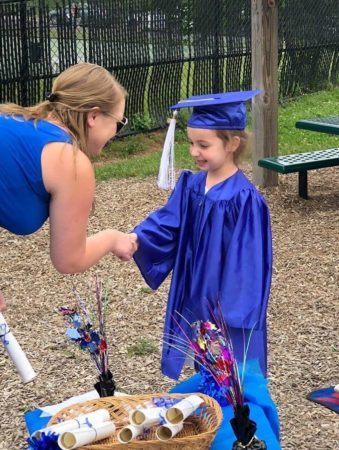 pre-kindergarten_girl_receiving_her_diploma_winwood_childrens_center_ashburn_va-339x450