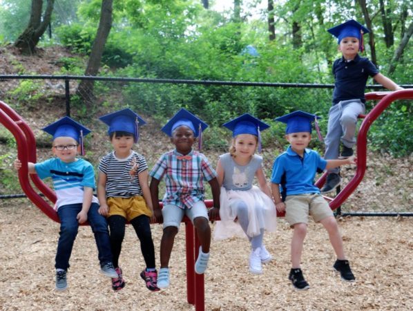 pre-kindergarten_graduates_sitting_on_playground_cadence_academy_preschool_smithfield_ri-598x450
