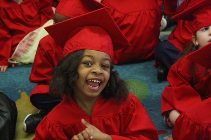pre-kindergarten_student_smiling_at_graduation_cadence_academy_preschool_northeast_columbia_sc-675x450