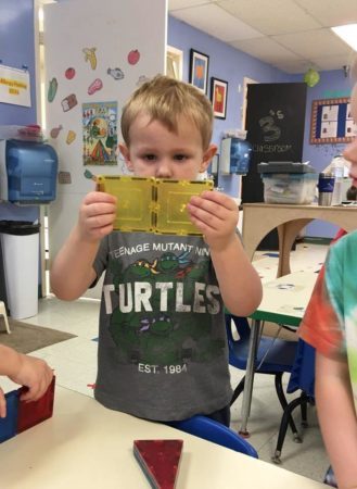 preschool_boy_attaching_magnetic_squares_cadence_academy_preschool_grand_west_des_moines_ia-329x450