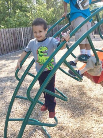 preschool_boy_climbing_on_playground_equipment_at_cadence_academy_eastfield_huntersville_nc-336x450