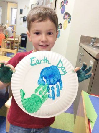 preschool_boy_holding_earth_day_paper_plate_art_carolina_kids_child_development_center_fort_mill_sc-336x450