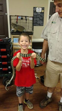 preschool_boy_holding_snake_sunbrook_academy_at_stockbridge_ga-253x450