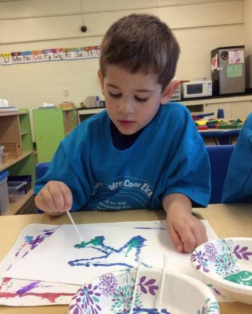 preschool_boy_painting_an_airplane_cadence_academy_preschool_ridgefield_ct-361x450