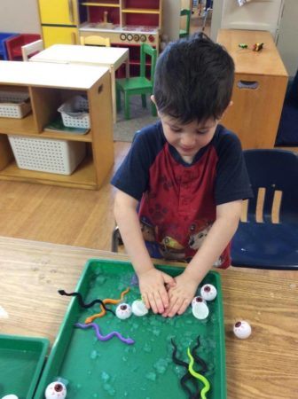 preschool_boy_playing_with_ice_snakes_and_eyeballs_next_generation_childrens_centers_natick_ma-336x450