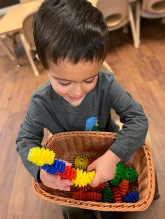 preschool_boy_playing_with_interlocking_plastic_pieces_sunbrook_academy_at_woodstock_ga-338x450