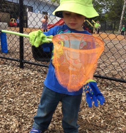 preschool_boy_playing_with_net_on_the_playground_at_cadence_academy_preschool_bourne_ma-426x450