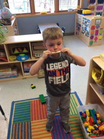 preschool_boy_playing_with_paper_kazoo_cadence_academy_preschool_johnston_ia-336x450