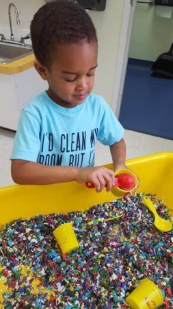 preschool_boy_playing_with_shredded_paper_fredericksburg_childrens_academy_fredericksburg_va-253x450