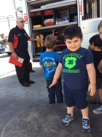 preschool_boy_posing_in_front_of_fire_truck_at_the_peanut_gallery_la_porte_tx-336x450