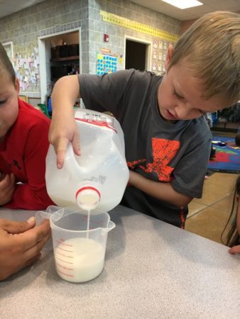 preschool_boy_pouring_milk_canterbury_academy_at_shawnee_crossings_shawnee_ks-338x450