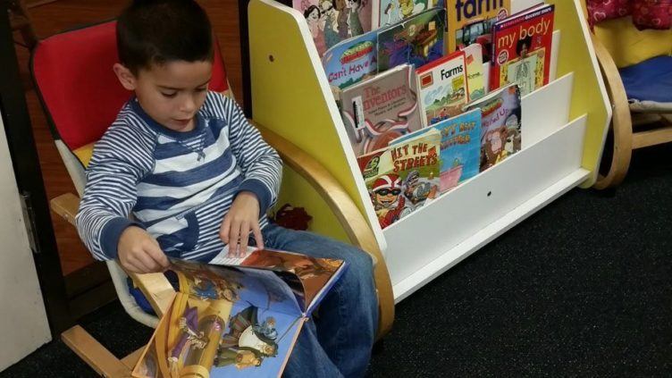 preschool_boy_reading_a_book_at_cadence_academy_preschool_dallas_tx-752x423