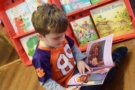 preschool_boy_reading_book_during_scholastic_book_fair_cadence_academy_preschool_mauldin_sc-675x450