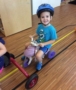 preschool_boy_riding_a_scooter_inside_cadence_academy_preschool_austin_cedar_park_tx-381x450