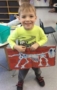 preschool_boy_showing_off_dinosaur_book_adventures_in_learning_naperville_il-283x450