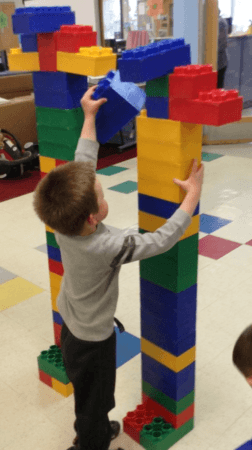 preschool_boy_stacking_large_blocks_cadence_academy_preschool_centennial_co-252x450