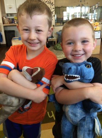 preschool_boys_hugging_stuffed_dinosaurs_at_cadence_academy_preschool_columbine_littleton_co-333x450
